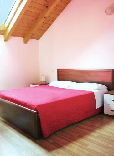 a bedroom with a large bed with a red blanket at "Il Cortile" Apartment in Colico