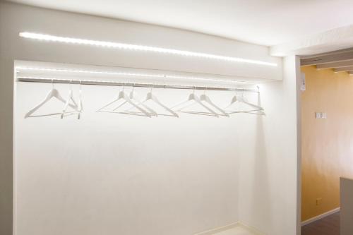 a bathroom with four racks of hangers at Secret Rhome Loft in Rome