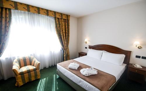 a hotel room with a bed and a chair at Relais Santo Stefano in Sandigliano