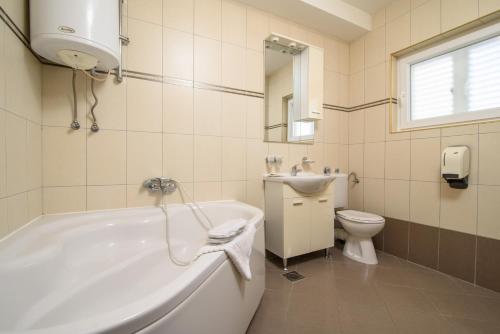 y baño con bañera, aseo y lavamanos. en B&B Villa Paula, en Trogir