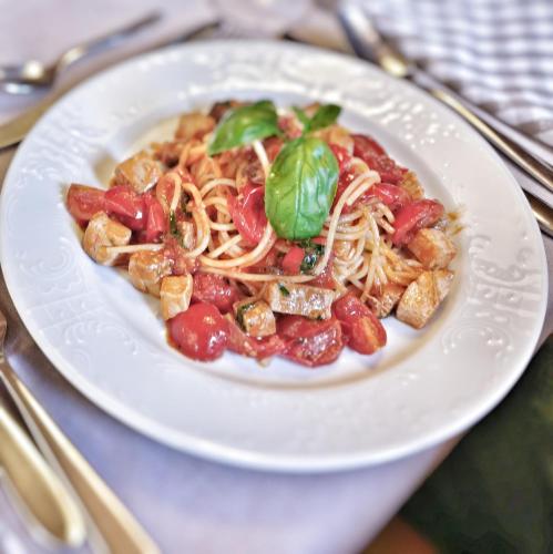 a white plate of food with noodles and meat at Lumen in Falcade