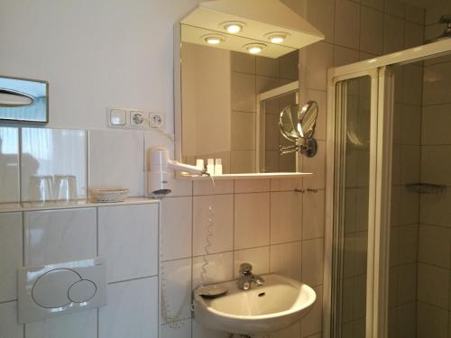 a bathroom with a sink and a mirror at Hotel Eifelstube in Rodder