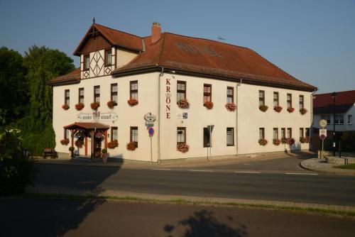 a large white building with flowers in front of it at Landgasthof & Hotel KRONE Eischleben in Ichtershausen