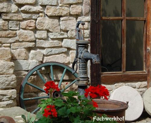 a flower planter next to a stone wall with a window at Hotel & Café Mohrenbrunnen in Eisenberg