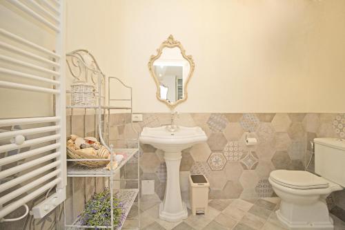 a bathroom with a sink and a toilet and a mirror at Romantic Benaco Salò in Salò