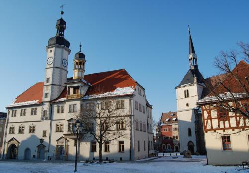 a large building with a clock tower on top of it at Hotel & Café Mohrenbrunnen in Eisenberg