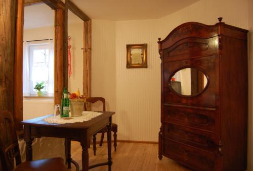 a room with a dresser and a table with a mirror at Hotel & Café Mohrenbrunnen in Eisenberg