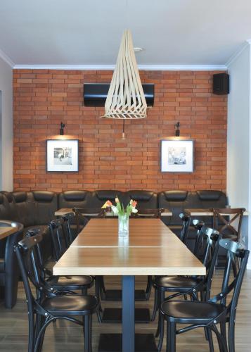 a dining room with a wooden table and chairs at Motel DB2000 in Biłgoraj
