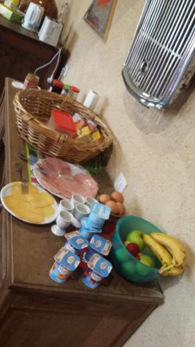 een tafel met eten en een mand met fruit en eieren bij La Roussilhe in Sousceyrac
