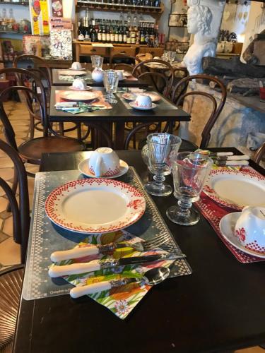 a table with plates and utensils on top at Maison & Tartine in Colombey-les-deux-Églises