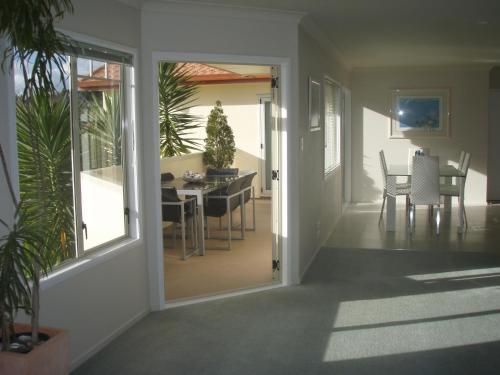 a hallway with a dining room and a dining table at Seascape Villa B&B in Tauranga