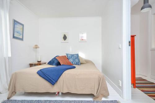 a bedroom with a bed with blue and orange pillows at Rent a House in Brodalen - Lysekil in Brastad
