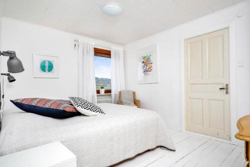a white bedroom with a bed and a window at Rent a House in Brodalen - Lysekil in Brastad