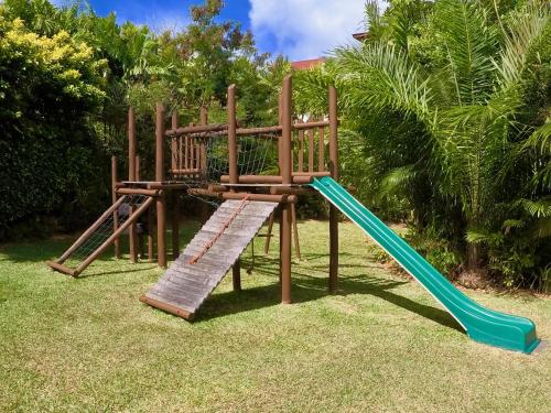 a wooden playground with a slide in the grass at Eden Island Apartment - P14A3 in Eden Island