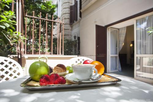 a tray of fruit and a cup of coffee on a table at Aldrovandi Residence City Suites in Rome
