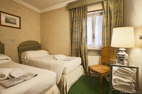 a hotel room with two beds and a window at Aldrovandi Residence City Suites in Rome