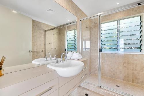 a bathroom with a white sink and a shower at Andari Holiday Apartments in Sunshine Beach