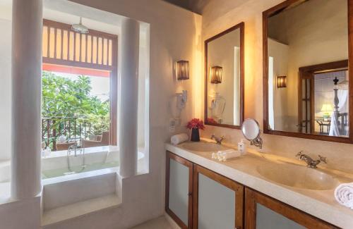a bathroom with two sinks and a tub and a mirror at Thambili House Galle Fort by Edwards Collection in Galle