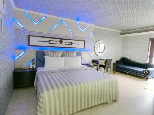 een slaapkamer met een kingsize bed en een bank bij Full Moon Boutique Motel in Hsinchu City