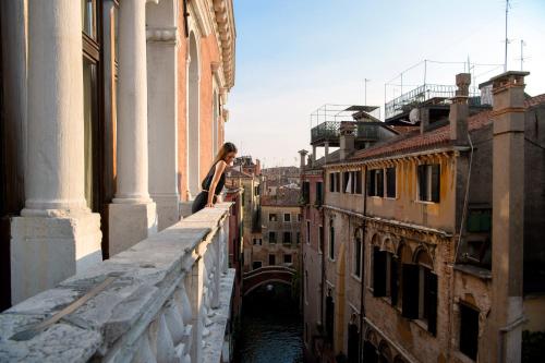 a woman standing on the ledge of a building at Ruzzini Palace Hotel in Venice