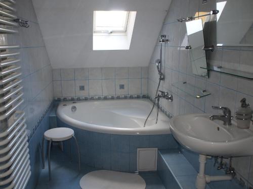 a bathroom with a tub and a sink at Apisoltysowka in Powązki