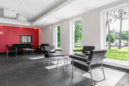 uma sala de espera com cadeiras e uma parede vermelha em Serways Hotel Bruchsal West em Forst