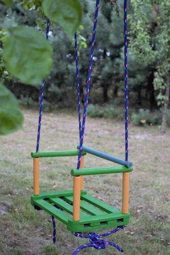 a green swing with blue ropes in a park at Siedlisko Bolek in Nadrybie