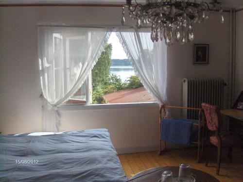 GnestaにあるMälby Säteri B&Bのベッドルーム1室(水辺の景色を望む窓付)