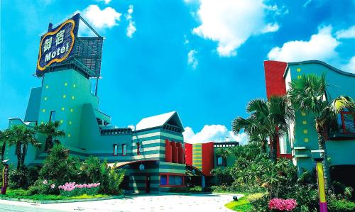 a building with palm trees in front of it at Royal Group Motel Wu Yin Branch in Kaohsiung