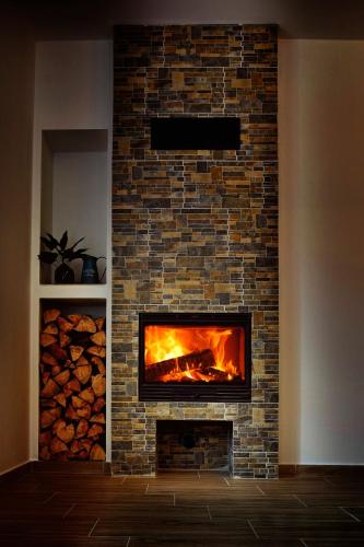 a brick fireplace with a fire in it at Holiday home Turovec in Tábor
