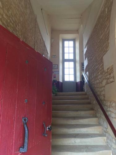 a red door in a hallway with stairs at Château d'Avanton in Avanton