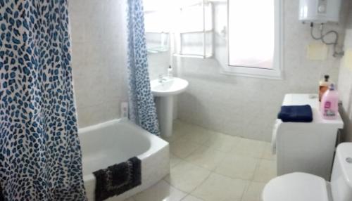 baño con cortina de ducha azul y lavamanos en Apartamento Céntrico Puerto Del Rosario, en Puerto del Rosario