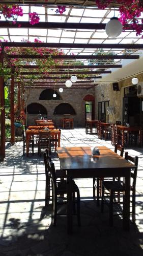 a patio with tables and chairs in a building at Hotel Dougas in Arkoudi