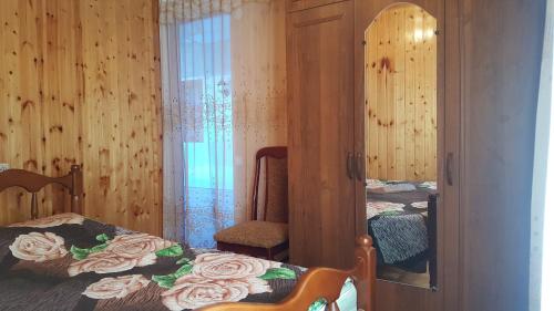 a bedroom with a bed and a mirror and a chair at Частный сектор in Sukhum