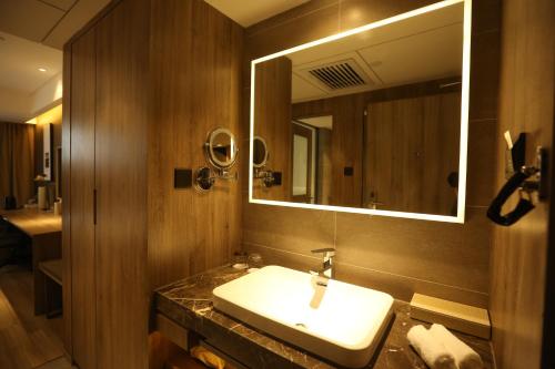 a bathroom with a sink and a mirror at Atour Hotel Shuangyong Ave in Yan'an