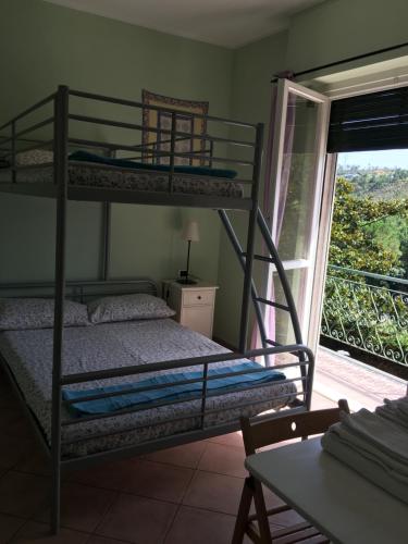 a bedroom with two bunk beds and a balcony at Agriturismo Valdolivo in Cogoleto
