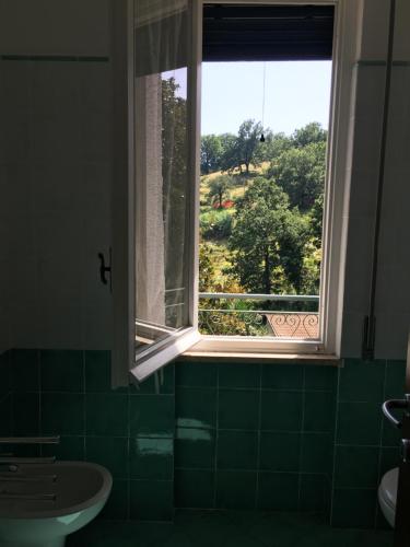 a bathroom with a window with a view of a field at Agriturismo Valdolivo in Cogoleto
