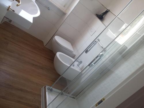 a bathroom with two toilets and a sink at Arenosu Comfort Country Guesthouse in Fertilia