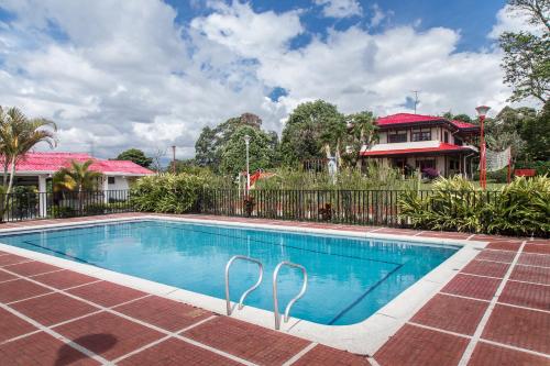 a swimming pool in front of a house at Agroparque Las Villas in Popayan