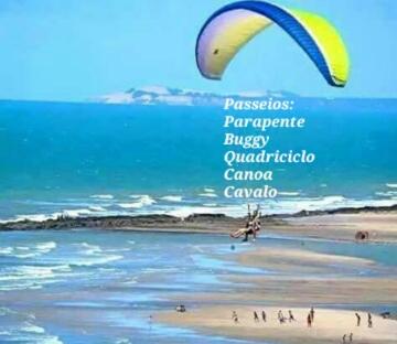a person flying a kite on a beach at EmanuelleSales - Corretora de Imóveis - "LUXURY RESIDENCES" creci 16949F in Canoa Quebrada