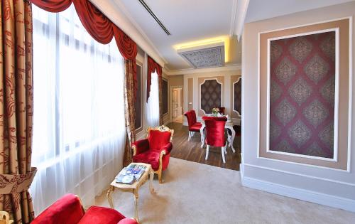 a living room with red chairs and a table at Legacy Ottoman Hotel Istanbul Old City in Istanbul