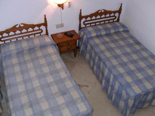two beds sitting next to each other in a room at Hostal Alicante in Granada