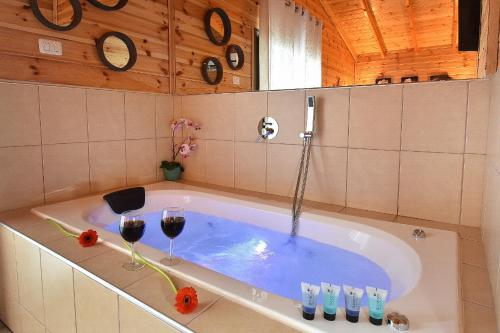 a bathroom with a tub with two glasses of wine at אחוזת חוף כנרת kinneret village in Tiberias