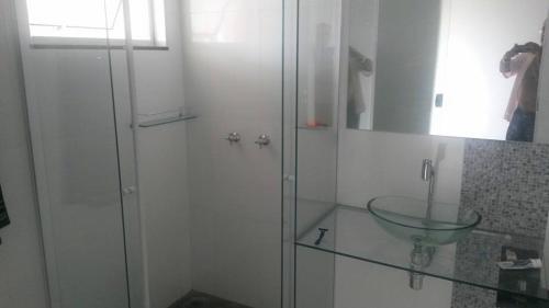 a bathroom with a glass sink and a shower at Arym Hotel in Aparecida do Taboado