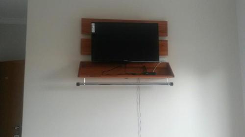a flat screen tv sitting on top of a shelf at Arym Hotel in Aparecida do Taboado