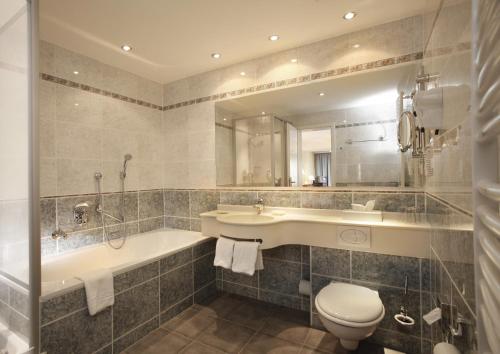 ein Badezimmer mit einer Badewanne, einem Waschbecken und einem WC in der Unterkunft Hotel Stadt Hannover in Göttingen