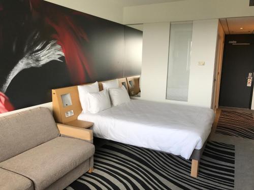 Postel nebo postele na pokoji v ubytování Novotel Poitiers Site du Futuroscope