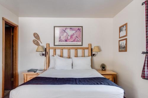 ein Schlafzimmer mit einem Bett und zwei Tischen mit Lampen in der Unterkunft Franciscan Lodge in Tahoe Vista