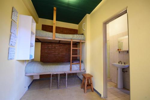 een kamer met 2 stapelbedden en een wastafel bij La Tosca Hostel in Puerto Madryn