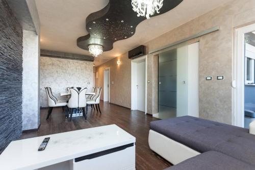 a living room with a couch and a dining room at Teo Apartment in Pula